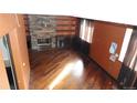 An empty living room with hardwood floors and a brick fireplace surrounded by built-in shelving at 6815 Hills Dr, Parker, CO 80138