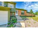 A cozy home front entrance is surrounded by beautiful landscaping leading to the front door at 2211 Sherman St, Longmont, CO 80501
