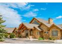 Charming stone home with a welcoming front porch and well-manicured landscaping at 15958 Shadow Mountain Ranch Rd, Larkspur, CO 80118