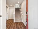 Inviting foyer with hardwood floors, a stairway to the upper level, and a sliding barn door at 11142 Bella Vita Dr, Broomfield, CO 80020