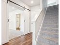 Upstairs hallway with carpet, a barn door, and a view into the bathroom at 11142 Bella Vita Dr, Broomfield, CO 80020