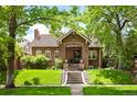 Charming single-Gathering home boasts an inviting front porch and beautifully landscaped front yard at 615 N Williams St, Denver, CO 80218