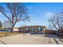 Ranch home with a large driveway and mature trees at 8318 Benton Way, Arvada, CO 80003