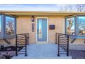 Modern front entry with a blue door and black railing at 8318 Benton Way, Arvada, CO 80003