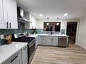 Modern kitchen featuring white and gray cabinets and quartz countertops at 8318 Benton Way, Arvada, CO 80003