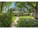 Charming green home with stone accents, complemented by lush lawn and trees at 1975 Cody St, Lakewood, CO 80215