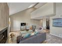 Spacious living room with vaulted ceilings, fireplace, skylight, wood flooring, and abundant natural light at 701 Harlan St # E72, Lakewood, CO 80214