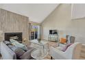 Inviting living room featuring high ceilings, a wood-burning fireplace, and comfortable seating arrangement at 701 Harlan St # E72, Lakewood, CO 80214
