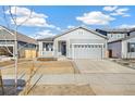 Two-car garage, front porch, and gray siding on a new construction home at 1547 Orchard St, Brighton, CO 80601