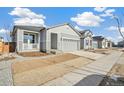 New construction home with gray siding, landscaping, and a two-car garage at 1547 Orchard St, Brighton, CO 80601