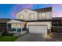 Charming two-story home boasts a cozy front porch, attached two-car garage and well-maintained lawn at 47300 Clover Ave, Bennett, CO 80102