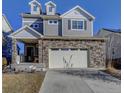 Attractive two-story home featuring a stone veneer, gray siding, and a well-manicured lawn under a clear blue sky at 26293 E Archer Ave, Aurora, CO 80018