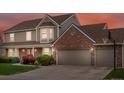 Charming exterior view of home showcasing the attached garage, brick facade, and colorful front yard landscaping at 5454 S Everett Ct, Littleton, CO 80123