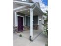 Covered front porch with stone detail and a plum-colored front door at 5537 Malta St, Denver, CO 80249