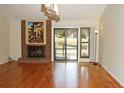 Bright living room featuring a brick fireplace, hardwood floors, and sliding glass doors to the yard at 6150 W Mansfield Ave # 33, Denver, CO 80235