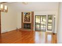 Cozy living room features a vaulted ceiling, a brick fireplace, and hardwood floors at 6150 W Mansfield Ave # 33, Denver, CO 80235