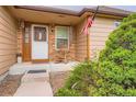 Inviting front porch with rocking chair detail and American flag at 4162 S Dunkirk Way, Aurora, CO 80013