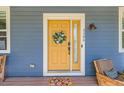 Inviting yellow front door with decorative wreath, leading to a stylish and well-maintained home at 3386 Beeler Ct, Denver, CO 80238