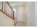Bright entryway with staircase, tiled floor, and access to half-bath at 5895 Biscay St # D, Denver, CO 80249