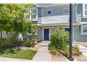 Front view of two-story townhouse with blue door and landscaping at 5895 Biscay St # D, Denver, CO 80249