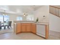Open kitchen with light wood cabinets, white appliances, and breakfast bar at 5895 Biscay St # D, Denver, CO 80249