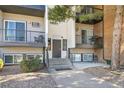 Close-up of the condo building entrance, featuring steps, a door, and outdoor seating areas at 1300 Golden Cir # 111, Golden, CO 80401