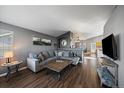 Spacious living room with gray sectional sofa, wood coffee table, and hardwood floors at 12590 Prince Creek Dr, Parker, CO 80134