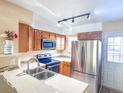 The kitchen features tile countertops, a double stainless sink, and stainless steel appliances at 15475 E Louisiana Ave, Aurora, CO 80017