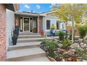 Inviting front entrance with steps leading to a cozy outdoor seating area and mature landscaping at 87 Prairie Ridge Rd, Highlands Ranch, CO 80126