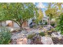 Landscaped front yard with stone features, mature trees, and a welcoming facade at 87 Prairie Ridge Rd, Highlands Ranch, CO 80126