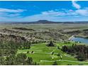 Breathtaking aerial view of the golf course community with mountain views and a serene lake at 7134 Kiowa Rd, Larkspur, CO 80118