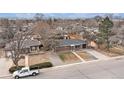 A cozy single-story home with a driveway, complemented by lush trees in a peaceful neighborhood setting at 3149 Wheeling St, Aurora, CO 80011