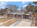 A well-maintained brick home featuring a driveway, garage, and manicured lawn creating curb appeal at 3149 Wheeling St, Aurora, CO 80011