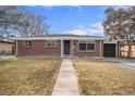 Charming brick home with a well-maintained lawn and a welcoming walkway to the front door at 3149 Wheeling St, Aurora, CO 80011