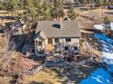 Aerial view of the backyard with a deck, patio, hot tub, fenced yard, and mature trees at 8390 E Summit Rd, Parker, CO 80138