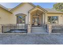 Close up of the front entrance featuring a decorative front door, stone pillars, and large windows at 8390 E Summit Rd, Parker, CO 80138