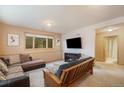 Inviting living room with carpet, comfortable seating, and a modern entertainment center at 31755 Ponderosa Way, Evergreen, CO 80439