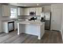 Bright kitchen featuring white cabinets, stainless steel appliances, an island with countertops, and wood flooring at 21996 E 39Th Pl, Aurora, CO 80019