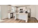 Stylish kitchen featuring white cabinets, stainless steel appliances, quartz countertops, and an island at 21996 E 39Th Pl, Aurora, CO 80019
