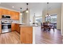 Open-concept kitchen featuring wood cabinets, stainless steel appliances, and modern flooring at 1194 Red Lodge Dr # 201, Evergreen, CO 80439