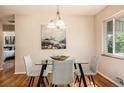 Elegant dining area featuring a modern glass table, seating for four, and stylish lighting fixtures at 2939 S Zurich Ct, Denver, CO 80236