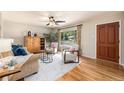 Cozy living room featuring hardwood floors, comfortable seating, and large windows for natural light at 2939 S Zurich Ct, Denver, CO 80236