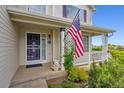Inviting front porch with decorative details and an American flag, creating a warm and welcoming entrance at 5302 S Robb Ct, Littleton, CO 80127