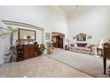 Bright living room with high ceilings, tile flooring, and a view into another room at 5302 S Robb Ct, Littleton, CO 80127