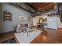 Open-concept living room with high ceilings, hardwood floors, grey walls and modern staircase to loft area at 1111 Osage St # 23, Denver, CO 80204