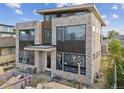 Front elevation showcasing modern design, featuring stone and wood finishes and large windows, enhanced curb appeal at 2010 Irving St, Denver, CO 80211