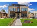 Contemporary home boasts a manicured lawn, stylish stone facade, and a unique rooftop terrace at 2010 Irving St, Denver, CO 80211