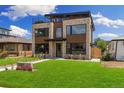Beautiful modern home features stone accents, a lush lawn, and a rooftop deck for outdoor living at 2010 Irving St, Denver, CO 80211