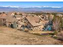 Aerial view of a home with a backyard, patio, playground, and stunning mountain views at 5886 Amber Ridge Dr, Castle Pines, CO 80108