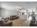 Open-concept living room with a cozy carpet and views into an adjacent kitchen at 1341 Kingfisher Ave, Brighton, CO 80601